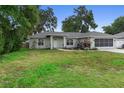 Charming single-story home features a well-maintained lawn and a screened garage at 1715 Queen Palm Dr, Edgewater, FL 32132