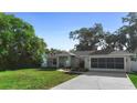 Lovely single-story home featuring a screened garage and well-manicured front yard at 1715 Queen Palm Dr, Edgewater, FL 32132