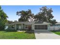 Well-kept single-story home with green lawn, charming walkway, and a screened garage at 1715 Queen Palm Dr, Edgewater, FL 32132