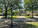 Lovely two-story home featuring a brick driveway and mature trees providing ample shade and curb appeal at 201 Asterbrooke Dr, Deland, FL 32724