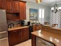 A well-appointed kitchen with stainless steel refrigerator and dark wood cabinets at 201 Asterbrooke Dr, Deland, FL 32724