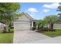 Beautifully landscaped single-Gathering home featuring a brick driveway and attached two-car garage at 220 Asterbrooke Dr, Deland, FL 32724