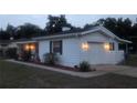 Well-maintained home exterior features a garage, manicured landscaping, and a freshly painted exterior at dusk at 2204 Poinsettia Dr, Deland, FL 32724