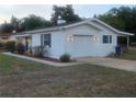 Well-maintained home exterior features a garage, manicured landscaping, and a freshly painted exterior at 2204 Poinsettia Dr, Deland, FL 32724