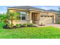 Landscaped front yard, green lawn, and brick driveway leading up to the welcoming home exterior at 2406 Kennington Cv, Deland, FL 32724