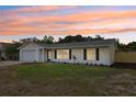 Single-story home with a well-manicured front lawn, a two-car garage, and beautiful sunset views at 2486 Shiprock Ct, Deltona, FL 32738