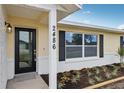 Beautiful front door with black trim, house number, and colorful landscaping at 2486 Shiprock Ct, Deltona, FL 32738