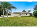 Single-story home with an attached two-car garage, well-maintained lawn, and mature palm trees at 2526 Chester Ave, New Smyrna Beach, FL 32168