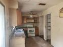 Outdated kitchen with dated cabinets, appliances and worn countertops at 2810 Kumquat Dr, Edgewater, FL 32141