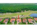 Aerial view of home with tile roof backing to golf course and trees at 2814 S Asciano Ct, New Smyrna Beach, FL 32168