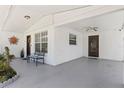 Inviting covered patio area with brick accents, bench, and easy access to the front door at 2824 Oak Lea Dr, South Daytona, FL 32119