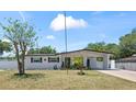 Charming single-story home with a carport, white exterior and well-manicured lawn at 2824 Oak Lea Dr, South Daytona, FL 32119