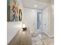 Inviting entryway with console table, sunflower art, and neutral rug at 3 Riverwalk Dr # 202, New Smyrna Beach, FL 32169