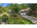 A charming home featuring a well-maintained lawn, mature landscaping, and an attached two-car garage at 30 Reflections Village Dr, Ormond Beach, FL 32174