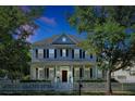 Charming two-story home featuring a welcoming front porch, white picket fence, and well-manicured landscaping at 3698 Lower Park Rd, Orlando, FL 32814
