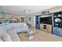 Comfortable living room with built-in shelving, TV, ceiling fan and view into dining area at 3855 S Atlantic Ave # 1405, Daytona Beach, FL 32118