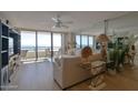 Bright living room with ocean view, sofa, and sliding glass doors to a balcony with seating at 3855 S Atlantic Ave # 1405, Daytona Beach, FL 32118