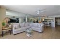 Living room featuring a large comfortable sofa, glass table, tile floors and decorative mirror wall at 3855 S Atlantic Ave # 1405, Daytona Beach, FL 32118