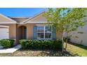 Close up of a house with pretty landscaping and a healthy young tree at 5708 Sunbonnet Way, St Cloud, FL 34771