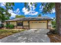 Home's two-car garage and concrete driveway complemented by lush, mature trees for shade and privacy at 5788 Devon St, Port Orange, FL 32127