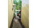 Outdoor walkway with brick pavers, landscaping and pergola covered gate to backyard at 6043 Strada Isle Way, Orlando, FL 32835