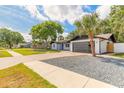 Lovely single-story home with a modern gray garage door, blue entry door, and manicured lawn at 612 Moonpenny Cir, Port Orange, FL 32127