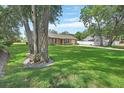 Spacious yard with mature trees surrounding a brick home at 672 Swarthmore Dr, Deland, FL 32724