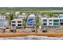Beachfront properties featuring decks, ocean views, and a blue beach house at 6847 S Atlantic Ave, New Smyrna Beach, FL 32169