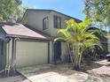Charming townhome featuring an attached garage and a lovely palm tree in the front yard at 805 N Clake St, Deland, FL 32724