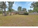 Brick home featuring a manicured lawn and mature shade trees at 1075 Burgoyne Rd, Deland, FL 32720