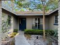 Inviting front entrance showcasing a blue front door framed by decorative shrubs, windows, and a walkway at 1120 Arden St, Longwood, FL 32750