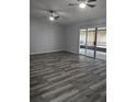 Spacious living room with hardwood floors, ceiling fans, and sliding glass doors to the lanai at 1250 Lemonwood Ave, Deland, FL 32724