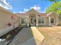 Inviting front entry with a well-landscaped yard leading to the home's front door at 1311 Fallwood Dr, Deltona, FL 32725