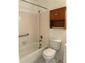 Clean bathroom featuring a tub and shower combination, toilet, and wood storage at 132 Wax Myrtle Ct, Sanford, FL 32773