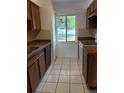 Functional kitchen featuring classic cabinetry, tile flooring, and a bright window at 132 Wax Myrtle Ct, Sanford, FL 32773