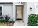 Inviting front entryway with a bright yellow door, manicured bushes, and decorative outdoor lighting at 1388 15Th St, Orange City, FL 32763