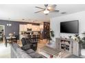 Open-concept living room and kitchen with modern decor, a ceiling fan, and bright natural light at 1388 15Th St, Orange City, FL 32763