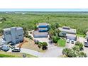 Aerial view of a blue house surrounded by lush greenery near a scenic body of water at 14 Marsh Ct, Ponce Inlet, FL 32127
