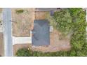 Overhead view of a single-story home with a dark roof and a concrete driveway surrounded by trees at 1435 6Th Ave, Deland, FL 32724