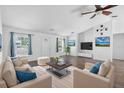 Bright living room features neutral furniture, wood floors, a ceiling fan and a decorative compass at 1435 6Th Ave, Deland, FL 32724