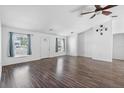 Bright living room features wood floors, white walls, a ceiling fan and a decorative compass at 1435 6Th Ave, Deland, FL 32724