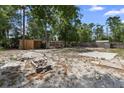 Spacious backyard with sandy ground cover and brick fire pit, perfect for enjoying cozy evenings outdoors at 1560 7Th Ave, Deland, FL 32724