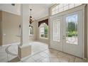 Inviting foyer with elegant tile flooring, a decorative chandelier, and large windows that fill the space with natural light at 1641 Timber Hills Dr, Deland, FL 32724