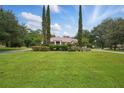 Expansive green lawn and meticulously landscaped front yard featuring tall, slender trees that frame the home at 1641 Timber Hills Dr, Deland, FL 32724