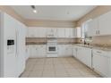 A modern kitchen featuring sleek white cabinets, granite countertops and stainless steel appliances at 1922 Cove Point Rd, Port Orange, FL 32128