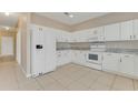 Bright kitchen features white cabinets, countertops and appliances, along with tile flooring at 1922 Cove Point Rd, Port Orange, FL 32128