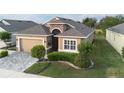 Single-story home boasts a manicured lawn, tasteful landscaping, and a welcoming entryway at 2435 Pawtucket Pass, Mount Dora, FL 32757