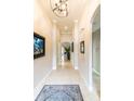 Inviting hallway featuring neutral walls, decorative art, a stylish light fixture, and tiled flooring, creating a welcoming ambiance at 2435 Pawtucket Pass, Mount Dora, FL 32757