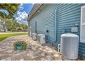 Exterior of the home showing modern HVAC system, brick patio, and well maintained landscaping at 2551 Cross Country Dr, Port Orange, FL 32128