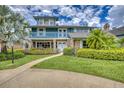 Stunning two-story home featuring a brick facade, balcony, lush landscaping, and inviting entrance at 2551 Cross Country Dr, Port Orange, FL 32128